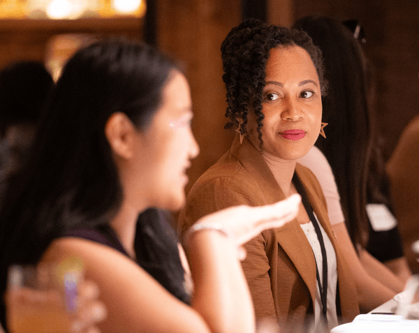 Two alumni speaking at a luncheon.